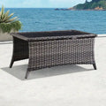 Table basse d'extérieur en rotin PE gris avec plateau en verre trempé et cadre en aluminium thermolaqué